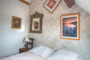 
a bedroom with a painting on the wall at Cottage Prairie Bonheur in Magny-les-Hameaux
