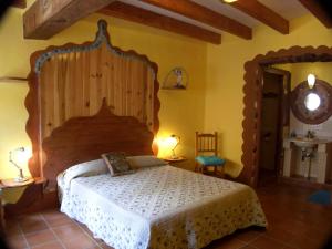 a bedroom with a large bed with a wooden headboard at Posada Del Río Carbo in Villahermosa del Río