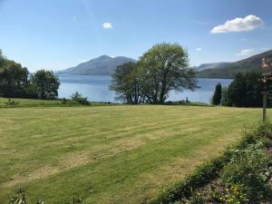 a grassy field next to a body of water at Campfield House in Fort William