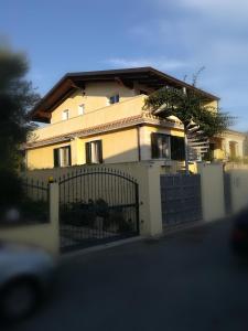 una casa amarilla con una puerta y una valla en Soggiornare a Cagliari en Cagliari