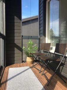 a patio with two chairs and a table and a plant at Meren tuoksu in Kalajoki