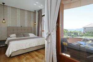 a bedroom with a bed and a large window at Villa Dalmatino in Pakoštane