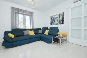 a living room with a blue couch and a table at Villa Dalmatino in Pakoštane