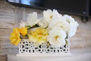 a white vase filled with white and yellow flowers at Villa Dalmatino in Pakoštane