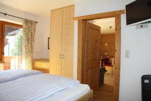 a bedroom with wooden walls and a bed with a tv at HAUS ERIKA apartments in Sölden