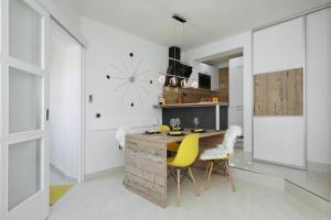 a kitchen with a wooden counter and yellow chairs at Villa Dalmatino in Pakoštane