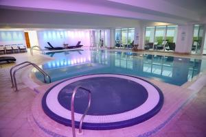 a large swimming pool in a large building at Towers Hotel & Spa in Swansea