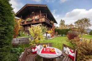 una mesa y sillas frente a una casa en Weberhäusl en Hopfgarten im Brixental