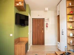 a hallway with a wooden door and green walls at Avenue Apartment in Pristina
