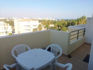 een witte tafel en stoelen op een balkon bij Waves Alvor in Portimão