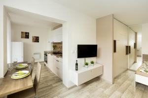 Apartmány Stožec - Nella Premium في ستوشيتس: مطبخ وغرفة طعام مع دواليب بيضاء وطاولة