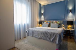 um quarto com uma cama com uma parede azul em ZIGZAG HOSTEL em Praia da Vitória