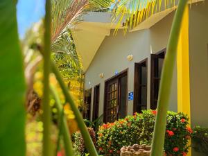 un edificio con flores y plantas delante de él en Pousada Costeira da Barra, en Maragogi