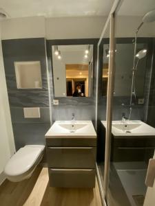 a bathroom with two sinks and a toilet and a mirror at Gite La Bastide in Ornans +8 photos