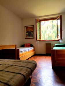 sypialnia z 2 łóżkami i oknem w obiekcie Monterosa Apartment - Champoluc #Bluchalet w mieście Champoluc