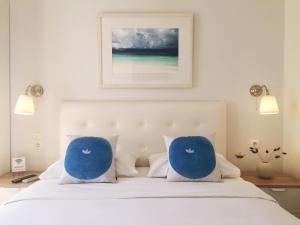 a bedroom with a bed with two blue pillows at Alexandris Hotel in Spetses