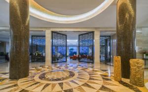 a lobby with a fountain in the middle of a building at Mövenpick Hotel du Lac Tunis in Tunis