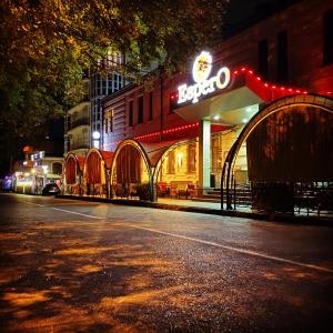 una calle de la ciudad por la noche con un edificio con un letrero de neón en Espero Hotel Resort & Spa, en Yessentuki