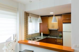 eine Küche mit Holzschränken und einer Spüle in der Unterkunft COLUMBUS´ HOME in Córdoba + 19 Fotos