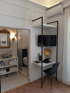 a room with a desk and a chair and a mirror at Esperia Boutique Hotel in Agrinio