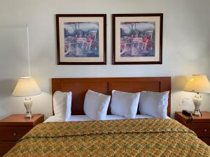 a bedroom with a bed with two pictures on the wall at International Inn on the Bay in Miami Beach