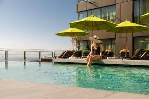 uma mulher sentada numa piscina ao lado de um edifício em Four Seasons Hotel Seattle em Seattle