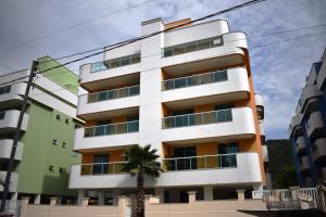 un edificio con una palmera delante de él en A082 - Ecopark - Apto de 2 quartos com piscina, en Bombinhas