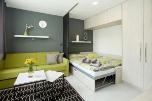 a bedroom with a bed and a couch and a table at Apartmány Stožec - Stela Premium in Stožec