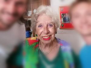 an older woman is smiling in front of a mirror at Pensione Rinascente in Pisa