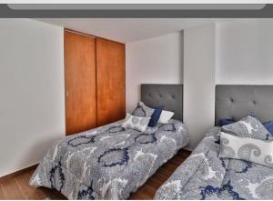 twee bedden naast elkaar in een slaapkamer bij Vive la Roma, ubicación ideal in Mexico-Stad