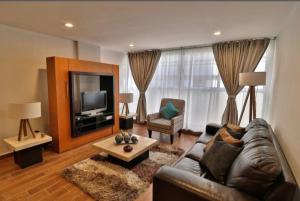 een woonkamer met een bank en een tv bij Vive la Roma, ubicación ideal in Mexico-Stad