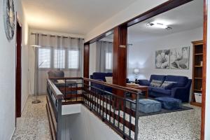 uma escada que leva a uma sala de estar com um sofá azul em VIVIENDA VACACIONAL CRUZ ALTA em Jerez de la Frontera