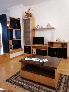un soggiorno con tavolino e TV di Casa da Floresta a Santiago da Guarda