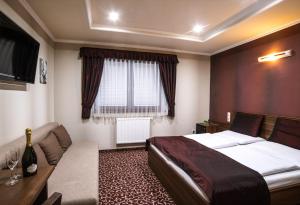 a hotel room with a bed and a couch at Corvin Pension and Restaurant in Veľký Meder