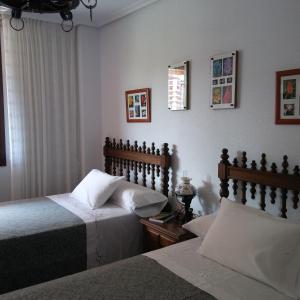 1 dormitorio con 2 camas y ventana en Habitaciones en El Sardinero-Santander, en Santander