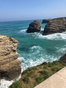 a view of the ocean with two large rocks at Las Catedrales in Barreiros