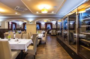 a dining room with white tables and chairs at Corvin Pension and Restaurant in Veľký Meder