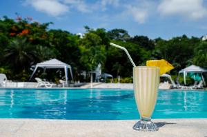 a drink sitting next to a swimming pool at Green9 Hotel & Beach Resort Same in Same