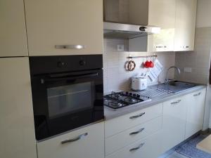 cocina con fogones negros y armarios blancos en Bell'appartamento, en Portoferraio
