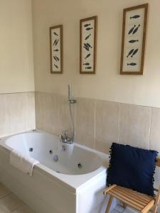 a white bath tub in a bathroom with a chair at Peel House Apartments - Contractor Friendly in Burton upon Trent