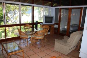 a screened in porch with a table and chairs and a television at Ocotal Beach Front House #25 in Ocotal