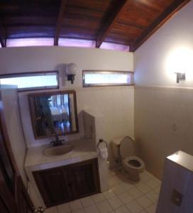 La salle de bains est pourvue d'un lavabo et de toilettes. dans l'établissement Ocotal Beach Front House #25, à Ocotal