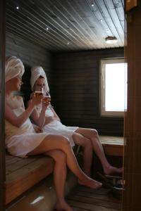two women sitting in a sauna drinking wine at Vuokatin Aateli Ritari & Lady in Vuokatti