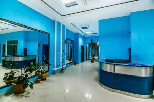 een grote kamer met blauwe muren en potplanten bij VİP Apartment number one in Baku