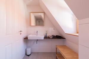 a white bathroom with a sink and a staircase at maindrei - schlafen am fluss in Margetshöchheim