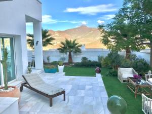 a patio with a couch and chairs on the grass at Villa Blanca Views & Pool in San José