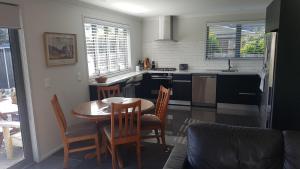 a kitchen with a table and chairs and a kitchen with a stove at Purakau Bed & Breakfast in New Plymouth