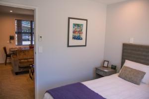 a bedroom with a bed and a chair and a table at 850 Cameron Motel in Tauranga