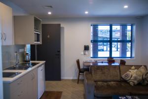 a kitchen and living room with a couch and a table at 850 Cameron Motel in Tauranga