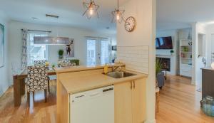 una cucina e un soggiorno con lavandino e orologio di Condo Entre Ville et Nature 2 a Magog-Orford